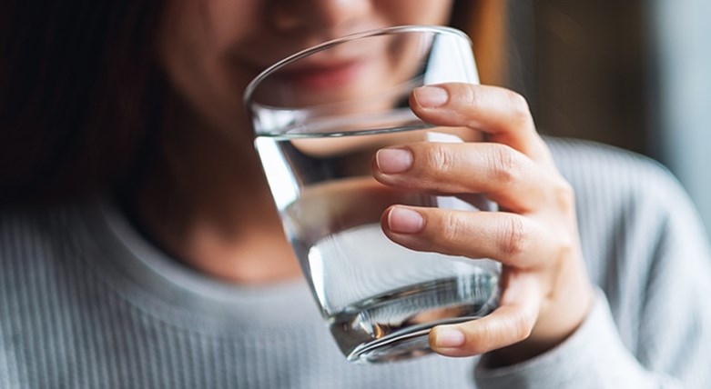 Eine Frau trinkt Wasser aus einem Glas